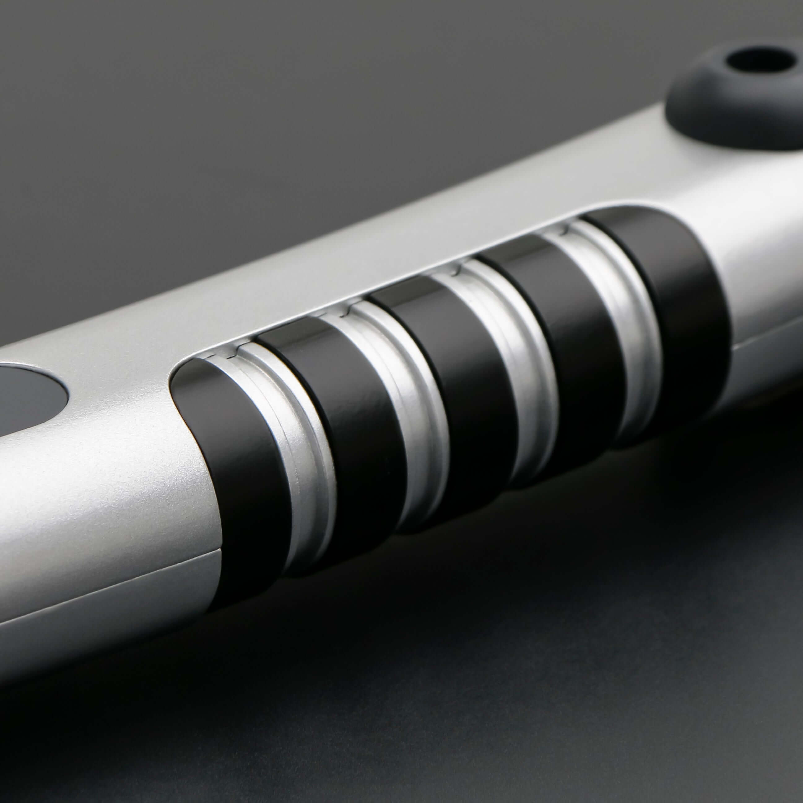 Tano lightsaber with silver and black anodized aluminum hilt, featuring 12 blade colors, 27 sound fonts, and options for Baselit, S-RGB, Neopixel, or Proffie cores, ideal for cosplay and light dueling.