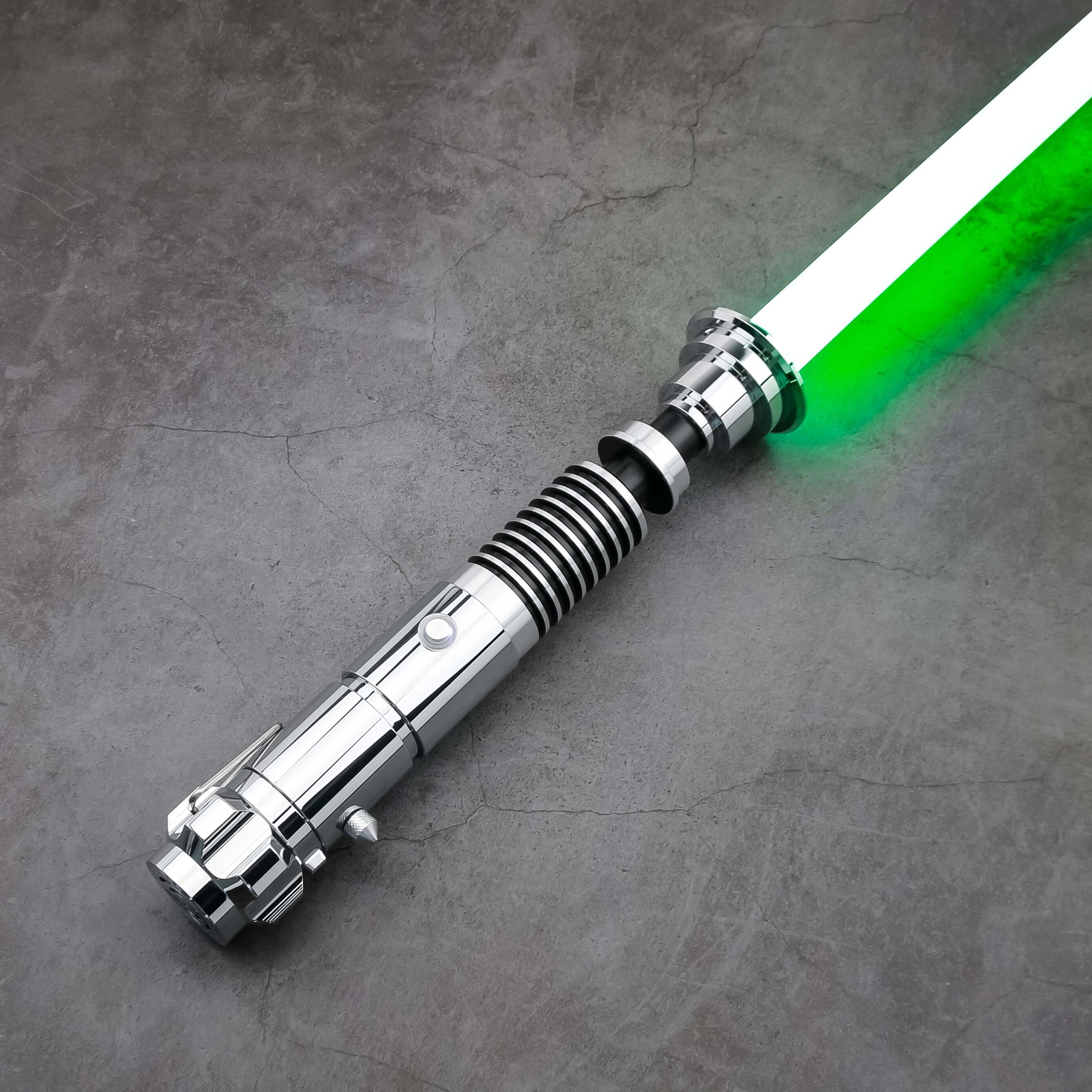 Luke SE Lightsaber from Novasaber, featuring a polished silver hilt with detailed gold accents and a vibrant green blade, inspired by the iconic weapon of Luke Skywalker from Star Wars