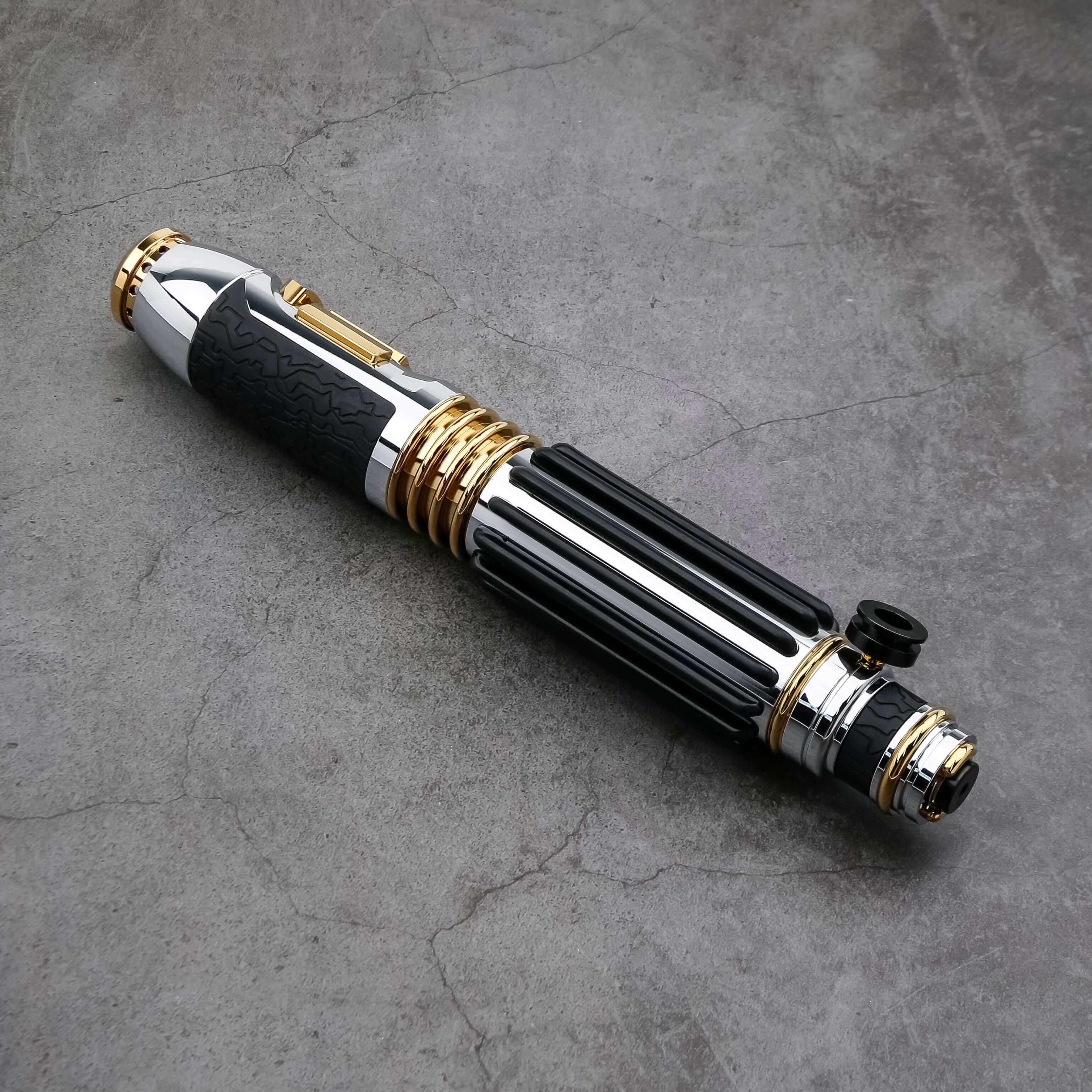 Windu Proffie lightsaber displayed on a textured surface, showcasing its sleek black and gold design.