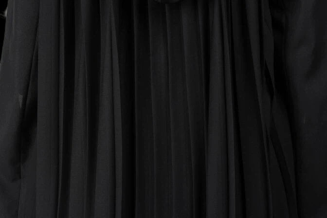 Close-up of the pleated fabric texture of the premium tactical enforcer suit in black.