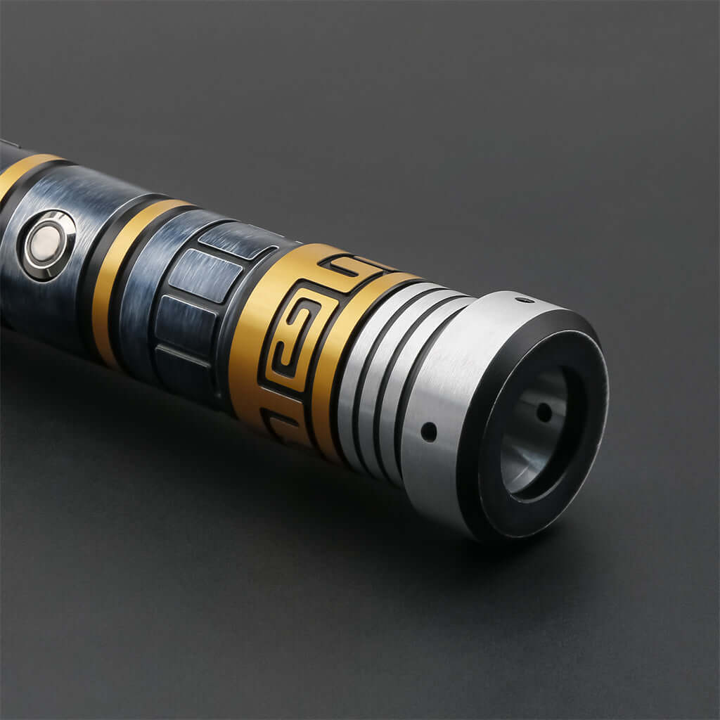 Close-up of the MV Champion lightsaber hilt, showcasing intricate designs and a metallic finish with gold accents.