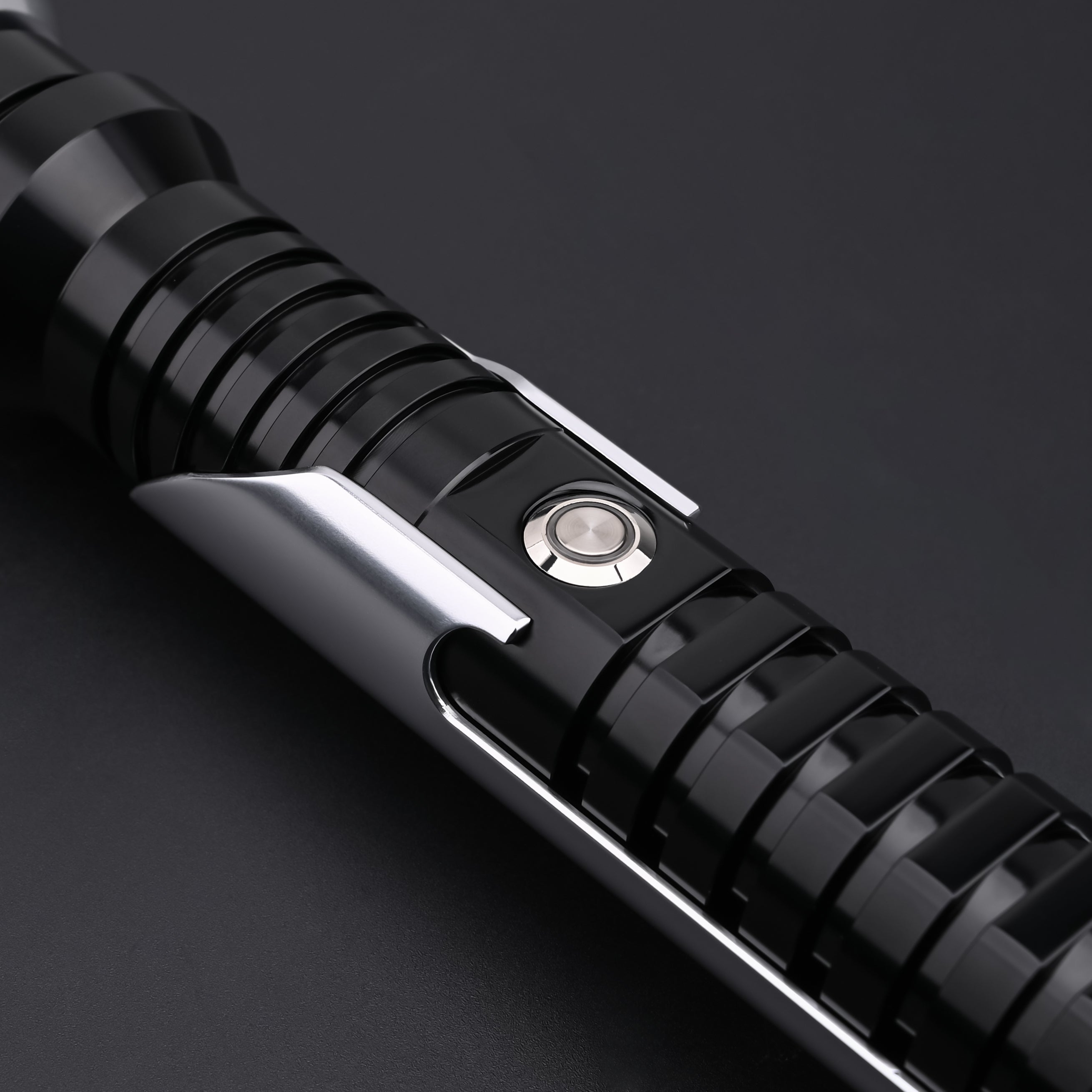 Close-up view of the Qui-Gon SE lightsaber control button and emitter details