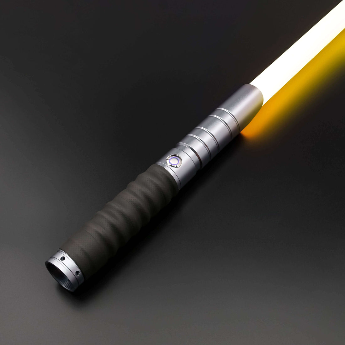 Combat lightsaber resting on a dark surface, showcasing its durable design and glowing blade.