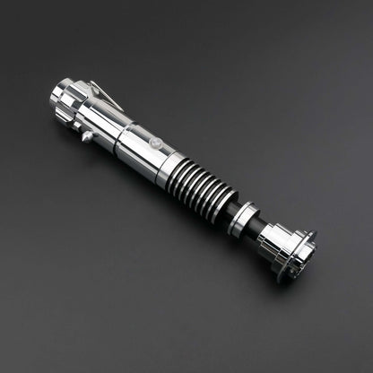 Luke SE Lightsaber from Novasaber, featuring a polished silver hilt with detailed gold accents and a vibrant green blade, inspired by the iconic weapon of Luke Skywalker from Star Wars