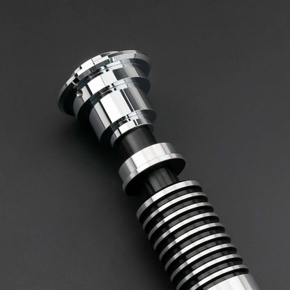 Luke SE Lightsaber from Novasaber, featuring a polished silver hilt with detailed gold accents and a vibrant green blade, inspired by the iconic weapon of Luke Skywalker from Star Wars