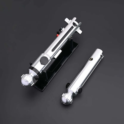 Ahsoka Tano CW lightsaber replica displayed on a black base, showcasing its sleek silver design and minimalist hilt.