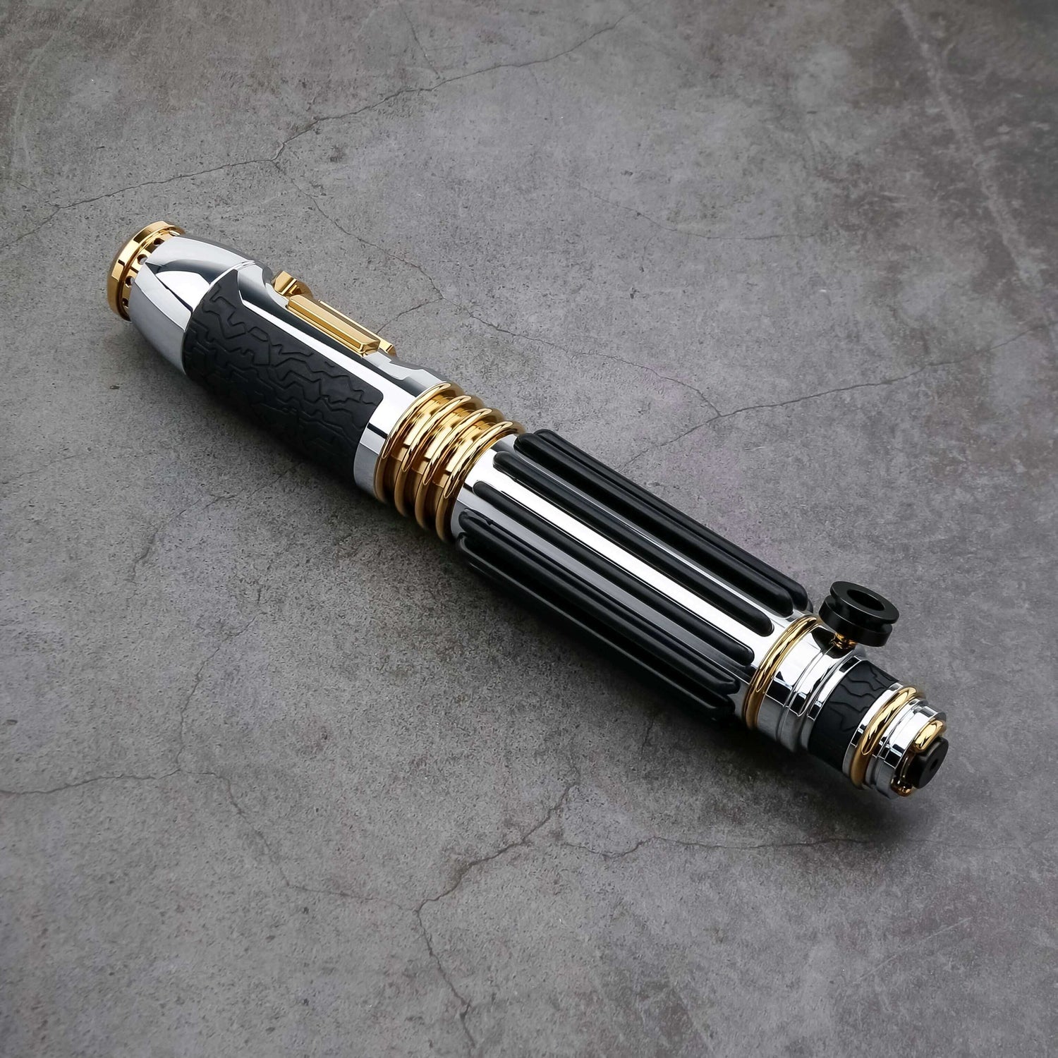 Windu Proffie lightsaber displayed on a textured surface, showcasing its sleek black and gold design.