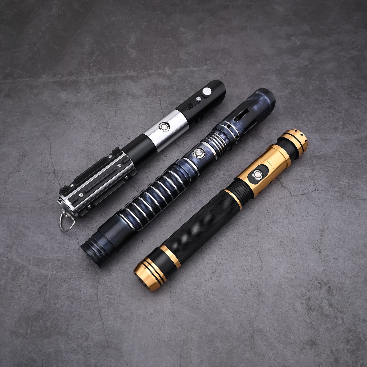Top-down view of the Jedi Trinity lightsaber hilts showcasing tactical design details