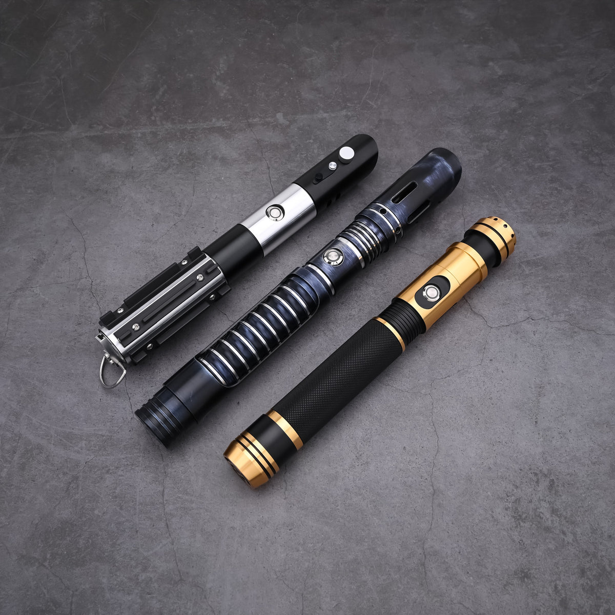 Top-down view of the Jedi Trinity lightsaber hilts showcasing tactical design details