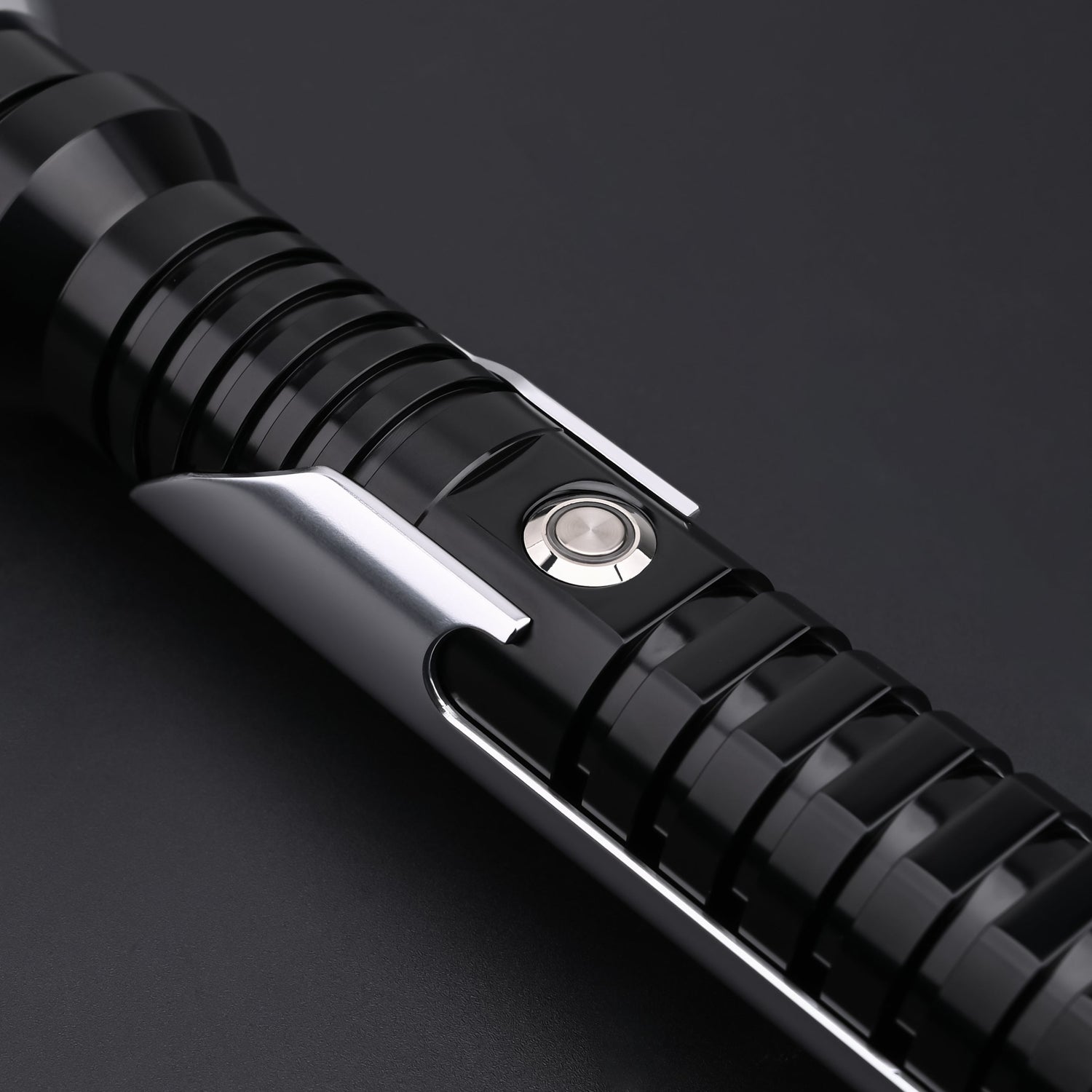 Close-up view of the Qui-Gon SE lightsaber control button and emitter details