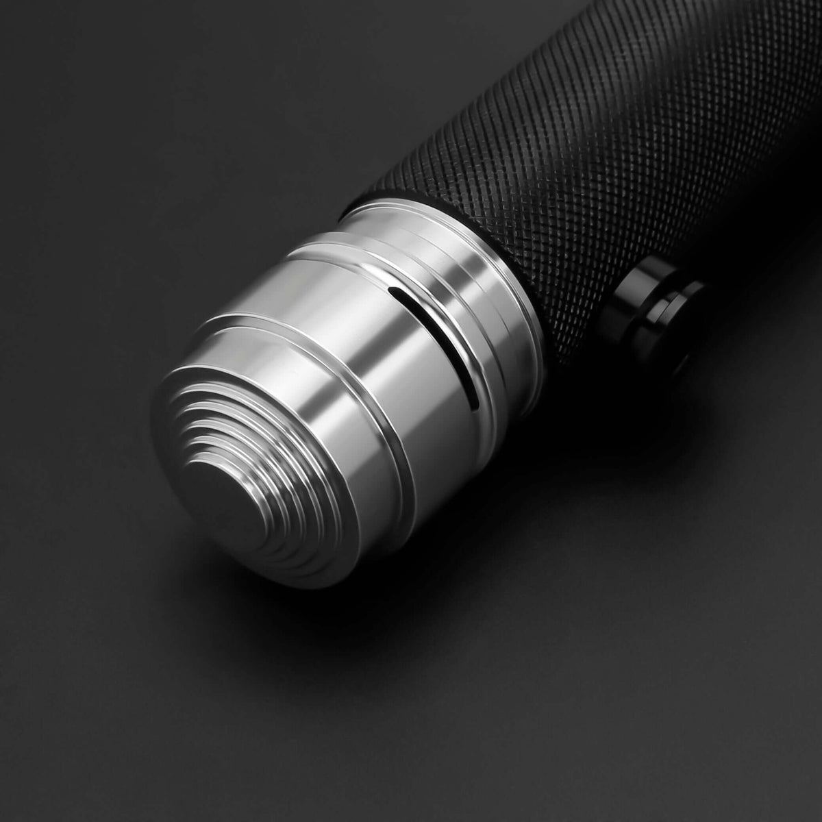 Close-up of tactical lightsaber and outfit bundle featuring a sleek silver handle and textured grip.